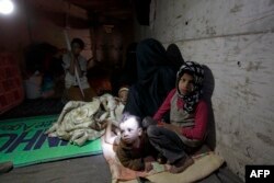 Members of a displaced Yemeni family sit in a manmade underground water tunnel where they are taking shelter after their houses were destroyed by airstrikes carried out by the Saudi-led alliance, in Sanaa, April 30, 2015.