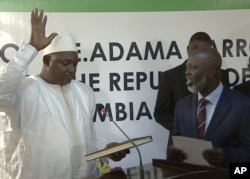 FILE - Adama Barrow, left, is sworn in as President of Gambia at Gambia's embassy in Dakar Senegal in this image taken from TV Thursday, Jan 19, 2017.