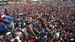 Kenyan opposition leader Raila Odinga, far left, holds a microphone as he addresses supporters in the Kibera area of Nairobi, Kenya, Aug. 13, 2017. Odinga urged his supporters to skip work on Monday in a protest against the country's disputed election and the police killings of rioters.