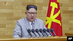 Pemimpin Korea Utara Kim Jong-un saat menyampaikan pidato tahunan Tahun Baru di lokasi yang tidak disebutkan di Korea Utara, 1 Januari 2018. (KRT via AP video)