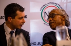 Democratic presidential hopeful Pete Buttigieg, left, speaks with the Rev. Al Sharpton at a breakfast event in Atlanta, Georgia, Nov. 21, 2019.