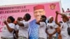 Des partisans dansent à côté d'une affiche du candidat à la présidence du Niger, Mohamed Bazoum, le 18 février 2021 à Niamey, avant le second tour de l'élection présidentielle du Niger le 21 février.