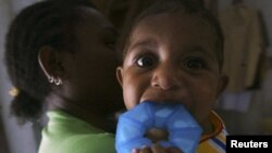 Seorang ibu dengan HIV menggendong bayinya yang tidak terinfeksi virus tersebut di sebuah tempat penampungan di Jayapura. (Foto: Dok)