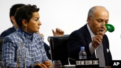 លោក Laurent Fabius ដែល​ជា​រដ្ឋ​មន្រ្តី​ក្រសួង​ការបរទេស​បារាំង​ និង​ជា​ប្រធាន​នៃ​កិច្ចប្រជុំ​ស្តី​ពី​បម្រែ​បម្រួល​អាកាសធាតុ ប្រើប្រាស់​ញញួរ​ដើម្បី​បង្ហាញ​ពី​ការ​អនុម័ត​នៃ កិច្ចព្រមព្រៀង។ 