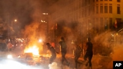 Polisi anti huru hara menembakkan gas air mata terhadap pengunjuk rasa anti-pemerintah, dalam aksi protes terhadap elit politik yang telah memerintah negara selama beberapa dekade, di Beirut, Lebanon, Jumat, 7 Agustus 2020. (Foto AP / Hassan Ammar)