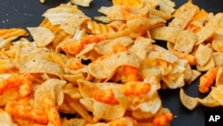 A mixture of salty snacks and chips is shown. The U.S. FDA recently announced new goals to help Americans reduce their sodium intake. (AP Photo/Keith Srakocic)