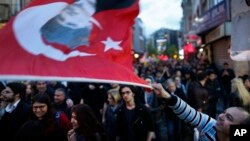 Supporters of the 'no' vote, one waving a Turkish flag with a picture of Mustafa Kemal Ataturk, the founder of modern Turkey participate in a protest regarding the referendum, in Istanbul, Wednesday, April 19, 2017. (AP Photo/Lefteris Pitarakis)