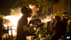 Protestors walk past a burning barricade near the Hong Kong Polytechnic University in Hong Kong on Saturday, Nov. 16, 2019.