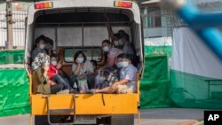 ពលករ​ចំណាកស្រុក​និង​ក្រុម​គ្រួសារ​របស់​ពួកគេ​ជិះ​រថយន្ដ​មួយ​គ្រឿង​ទៅ​កាន់​មន្ទីរពេទ្យ​មួយ​ នៅ​ខេត្ត Samut Sakhon ប្រទេសថៃ ថ្ងៃទី៤ ខែមករា ឆ្នាំ២០២១។ 