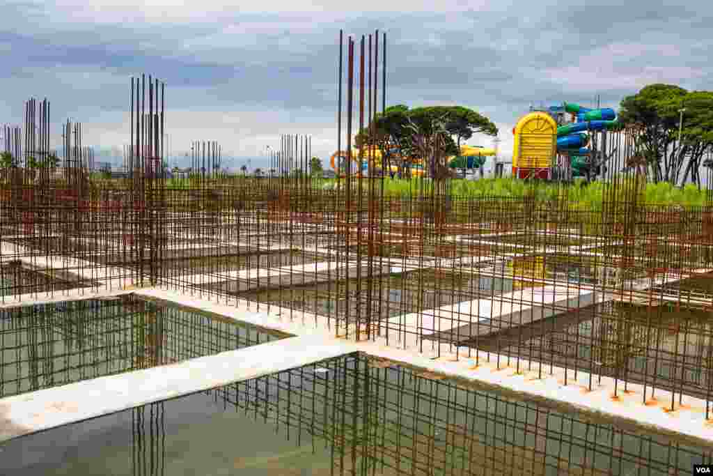 Metal rods rust and rainwater sits in the concrete foundation of a stopped beach view construction project. (V. Undritz for VOA)