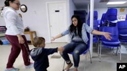 니카라과에서 미국으로 밀입국하다 적발된 여성이 21일 텍사스 매컬런의 한 구호단체 센터에서 아들을 만나고 있다. 