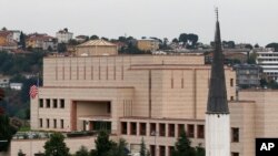 FILE - A mosque's minaret is seen backdropped by the United States consulate building in Istanbul, Aug. 11, 2015. 