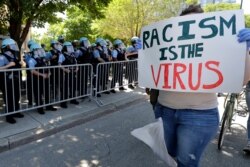 A demonstrator holds a sign during the March for Justice in honor of George Floyd, June 6, 2020, in Chicago. Demonstrators who gathered at Union Park marched through the city's West Side as the city prepared for another weekend of rallies.