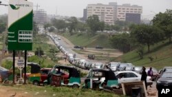 FILE - Cars line up to buy fuel at a petrol station in Abuja, Nigeria, Friday, April 1, 2016. Nigerian labor and civil society groups say their strike planned for Wednesday against a hike in fuel prices will go on as scheduled.