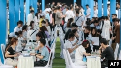 在中国西南部四川省宜宾市，大学毕业生和青年正在参加一场招聘会。(2023年6月14日)