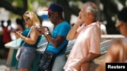 Cubans check their phones at an internet hotspot in Havana, Cuba, Aug. 10, 2018. A day of free, expanded internet was provided by the state-run telecommunications company, Aug. 14, 2018.