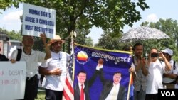 រូប​ឯកសារ៖ បាតុករ​កាន់​បដា​រូប​លោក កឹម សុខា និងលោក សម រង្ស៊ី មេដឹកនាំ​គណបក្ស​ប្រឆាំង នៅក្នុង​ការ​ប្រមូល​ផ្តុំ​គ្នា​មួយ នៅ​ក្បែរ​រដ្ឋ​សភា​អាមេរិក រដ្ឋធានី​វ៉ាស៊ីនតោន ថ្ងៃទី១៧ ខែកក្កដា ឆ្នាំ២០១៩។ (ទែន សុខស្រីនិត/VOA)