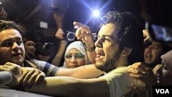 Wartawan Berbahasa Arab Al Jazeera Abdullah Elshamy disambut reman dan keluraganya setelah dibebaskan dari sebuah penjara di Kairo, Selasa sore (17/6).