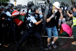 Police try to disperse protesters near a flag-raising ceremony for the anniversary of Hong Kong handover to China in Hong Kong, July 1, 2019.