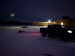 Keith Hernandez drinks a beer as his friends pull him with their truck on a snow-covered road in Waco, Texas, on Feb. 17, 2021, as severe winter weather over the last few days has forced road closures and power outages over the state.