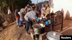 Para pengungsi Sudan menunggu untuk menerima makanan dari dapur amal, sementara perang saudara telah berlangsung selama setahun, di kota Omdurman, Sudan. 