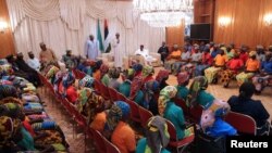 Le président Muhammadu Buhari et des lycéennes de Chibok, à Abuja, au Nigeria, le 7 mai 2017.