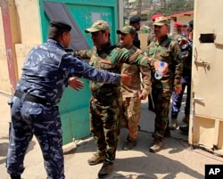 Security forces are searched before casting their votes in early voting for Iraq's security forces ahead of Saturday's national parliamentary elections, in Baghdad, Iraq, May 10, 2018.