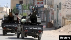 Members of Libyan internationally recognized pro-government forces ride in military vehicles on the outskirts of Tripoli, Libya, April 10, 2019.