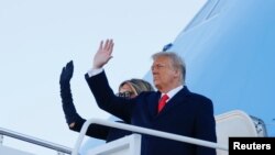 Le président Donald Trump et la première dame Melania Trump saluent alors qu'ils montent à bord d'Air Force One à la base commune d'Andrews, Maryland, États-Unis, le 20 janvier 2021.
