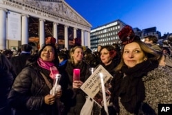 People hold candles as they protest in solidarity with the Women's March in Washington at the same time as the U.S. Presidential inauguration, in Brussels on Jan. 20, 2017.