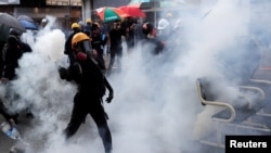 2019年10月1日，中国香港的国庆日，一名反政府示威者在沙田区的一场抗议活动中向其扔催泪弹罐。(资料照)