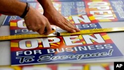 Tom Cushing, a production expert at Fast Signs, cuts down a sheet of anti-Senate Bill 1062 signs that read "Open for Business to Everyone," in Phoenix, Arizona, Feb. 26, 2014.
