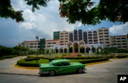 FILE - A vintage car passes in front of the Four Points by Sheraton hotel in Havana, Cuba, June 28, 2016. American hotel giant Starwood has begun managing this hotel owned by the Cuban military.