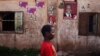 A child walks past posters for political candidates plastered on a house in Bamako, July 22, 2013.