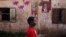 A child walks past posters for political candidates plastered on a house in Bamako, July 22, 2013.