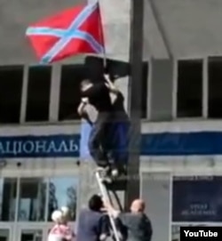 Rebels raise the DNR flag on the campus of Donetsk National University in September of 2014.