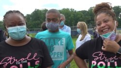 Janice Nelson, left, brought her 14-year-old son to the high school in hopes of catching a glimpse of the first Black vice presidential nominee, August 12, 2020. (E. Sarai/VOA)