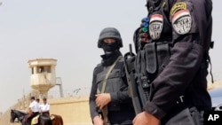 Egyptian policemen secure Egypt’s national police academy, where an Egyptian criminal court sentenced ousted Islamist President Mohammed Morsi and 12 Brotherhood leaders and Islamist supporters to 20 years in prison over the killing of protesters in 2012,