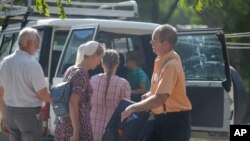 Tampak orang-orang menaiki kendaraan untuk menuju bandara dari kantor kelompok misionaris Christian Aid Ministries di Titanyen, Haiti, pada 16 Desember 2021. Seluruh anggota kelompok tersebut yang diculik oleh geng kriminal Haiti telah dibebaskan. (Foto: AP/Odelyn Joseph)