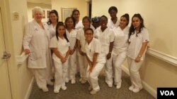 Linda Hall poses with the students in the CNA class. (VOA/F.Elmasry)