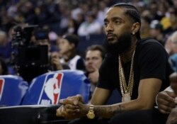 FILE - Rapper Nipsey Hussle watches an NBA basketball game between the Golden State Warriors and the Milwaukee Bucks, March 29, 2018, in Oakland, Calif.