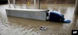 After helping the driver of the submerged truck get to safety, a man floats on the freeway flooded by Tropical Storm Harvey on Aug. 27, 2017, near downtown Houston.