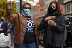 FILE - Sen. Kamala Harris, D-Calif., then the Democratic vice presidential nominee, and Rep. Marcia Fudge, D-Ohio, wave to employees of Zanzibar Soul Fusion restaurant during a campaign event in Cleveland, Oct. 24, 2020.