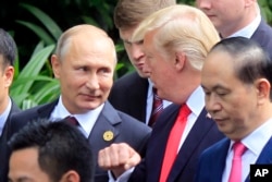 FILE - Russian President Vladimir Putin (L) and U.S. President Donald Trump talk as they arrive for the family photo session during the Asia-Pacific Economic Cooperation (APEC) Summit in Danang, Vietnam, Nov. 11, 2017.
