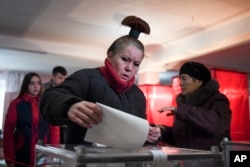A woman casts her ballot at a polling station during rebel elections in Donetsk, Ukraine, Nov. 11, 2018.