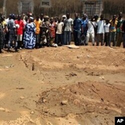 Mazauna unguwar Yopougon a birnin Abidjan su na tsaye a wani wurin da ake zargin cewa an binne dimbin gawarwaki a ciki.