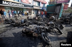 Burnt vehicles, set on fire Tuesday night following a protest by people belonging to Rajput community against the release of the upcoming Bollywood movie 'Padmaavat,' are seen outside a multiplex in Ahmedabad, India Jan. 24, 2018.