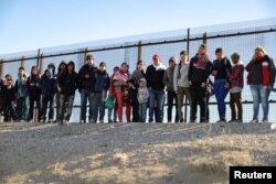FILE - A group of Central American migrants surrenders to U.S. Border Patrol Agents south of the U.S.-Mexico border fence in El Paso, Texas, March 6, 2019.