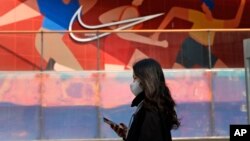 រូបឯកសារ​៖ អតិថិជន​ម្នាក់​ដើរ​​កាត់​ស្លាកសញ្ញា​ក្រុមហ៊ុន Nike នៅ​ក្នុង​មជ្ឈមណ្ឌល​ពាណិជ្ជកម្ម​មួយ​ក្នុង​ទីក្រុង​ប៉េកាំង ប្រទេស​ចិន ថ្ងៃទី២៥ ខែមីនា ឆ្នាំ២០២១។ 