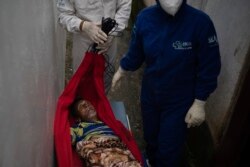 Emergency workers carry Jose Rocha on a hammock to a field hospital treating suspected COVID-19 patients in Manacapuru, Amazonas state, Brazil, June 1, 2020.